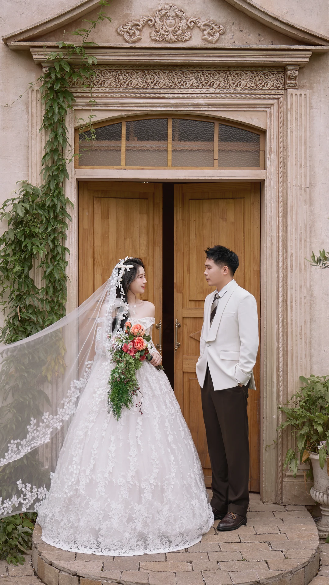 周杨与肖娇在复古门廊前相视而立的全身婚纱照
